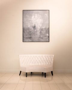 Photo of an abstract painting above a vintage style leather couch
